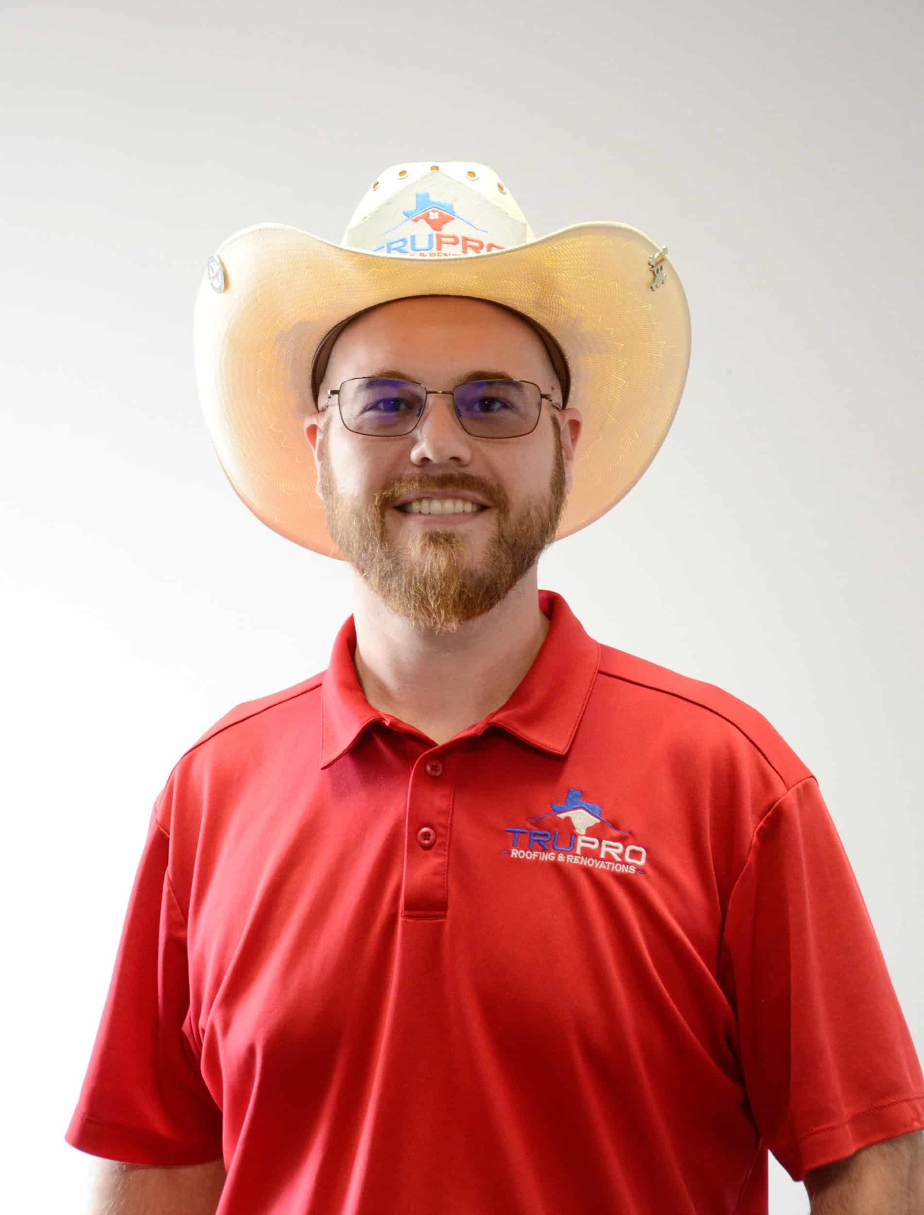 Roofing contractor wearing a TruPro hat and red polo shirt, smiling at the camera.