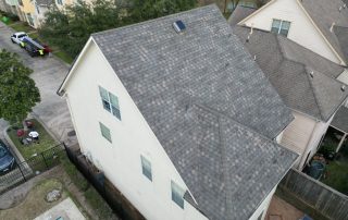 Roof replacement on a residential home with new asphalt shingles installed.