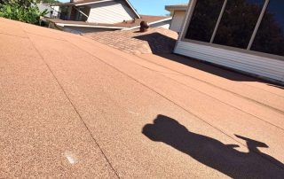 Roofers working on a residential roof with safety equipment.