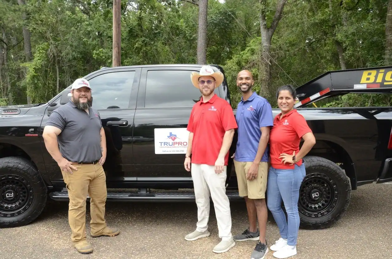 TruPro Roofing team standing next to a black truck with company logo.